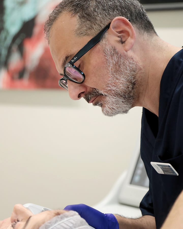 Il Prof. Coricciati chino su un paziente durante una visita
